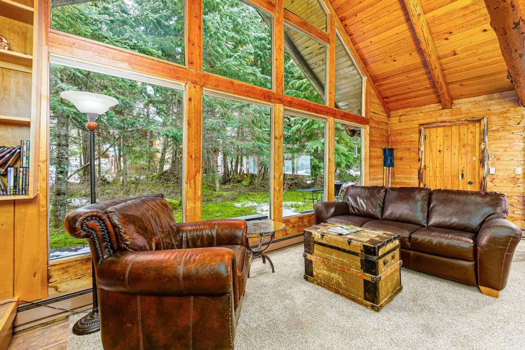 Log cabin living executed exactly the way it should be. Alpine Meadows Log Cabin sits a mile from Girdwood Park and minutes from the direct base of Alyeska Resort—offering a clean mountain escape that allows you to completely disconnect from the digital noise. The architecture features massive traditional log walls, a forest closing in on all sides, an expansive wrap-around deck built for summer sunbathing or stargazing, and large picture windows that flood the rustic space with natural light. Stowe the central wood stove on cold winter nights, cook real meals in the full kitchen, and use the private washer and dryer to keep gear dry. Standard Specs: Fully equipped kitchen with complete cookware, traditional wood stove, expansive private deck, private in-unit washer/dryer, flat-screen TV, high-speed WiFi, and keypad entry. Driveway parking for two vehicles. Sleeps 6.