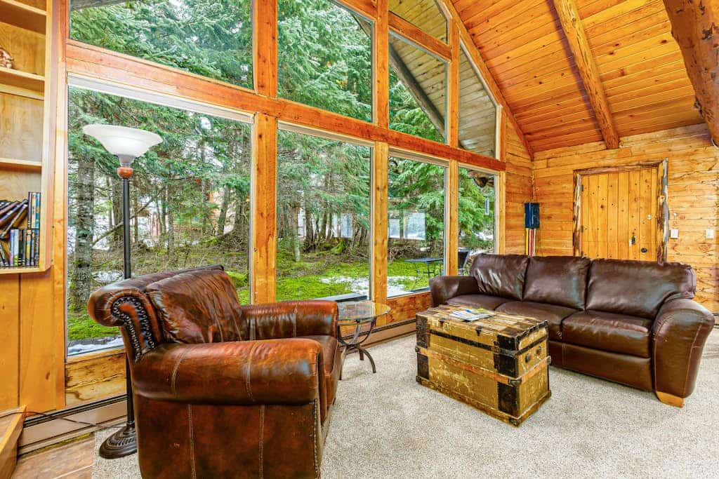 Log cabin living executed exactly the way it should be. Alpine Meadows Log Cabin sits a mile from Girdwood Park and minutes from the direct base of Alyeska Resort—offering a clean mountain escape that allows you to completely disconnect from the digital noise. The architecture features massive traditional log walls, a forest closing in on all sides, an expansive wrap-around deck built for summer sunbathing or stargazing, and large picture windows that flood the rustic space with natural light. Stowe the central wood stove on cold winter nights, cook real meals in the full kitchen, and use the private washer and dryer to keep gear dry. Standard Specs: Fully equipped kitchen with complete cookware, traditional wood stove, expansive private deck, private in-unit washer/dryer, flat-screen TV, high-speed WiFi, and keypad entry. Driveway parking for two vehicles. Sleeps 6.