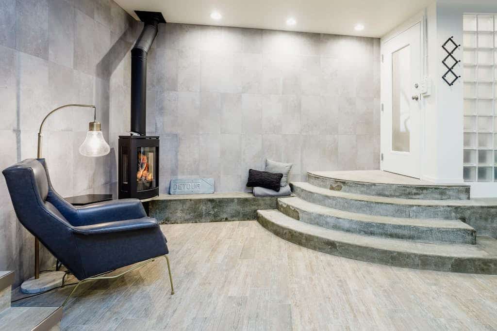 Industrial-chic finishes meet a private park-like setting. Tucked directly into downtown Anchorage's historic Bootlegger Cove neighborhood, this unique triplex unit features a bright interior with large windows that pull in natural light and capture clean views of the Cook Inlet waters. The sleek interior boasts a custom gas fireplace, modern design elements, and a high-end kitchenette packed with gourmet gadgets including an air fryer and a Ninja blender system. The master bedroom opens directly onto a beautifully furnished garden patio, complete with a private outdoor hot tub. Walk to the Tony Knowles Coastal Trail, downtown eateries, and museums in seconds. Standard Specs: Premium kitchenette (air fryer, Ninja system, toaster, fridge), built-in gas fireplace, private outdoor hot tub, shared garden patio, flat-screen TV, high-speed WiFi, and keypad entry. Driveway parking for one vehicle. Built for small families or executive stays. Sleeps 5.