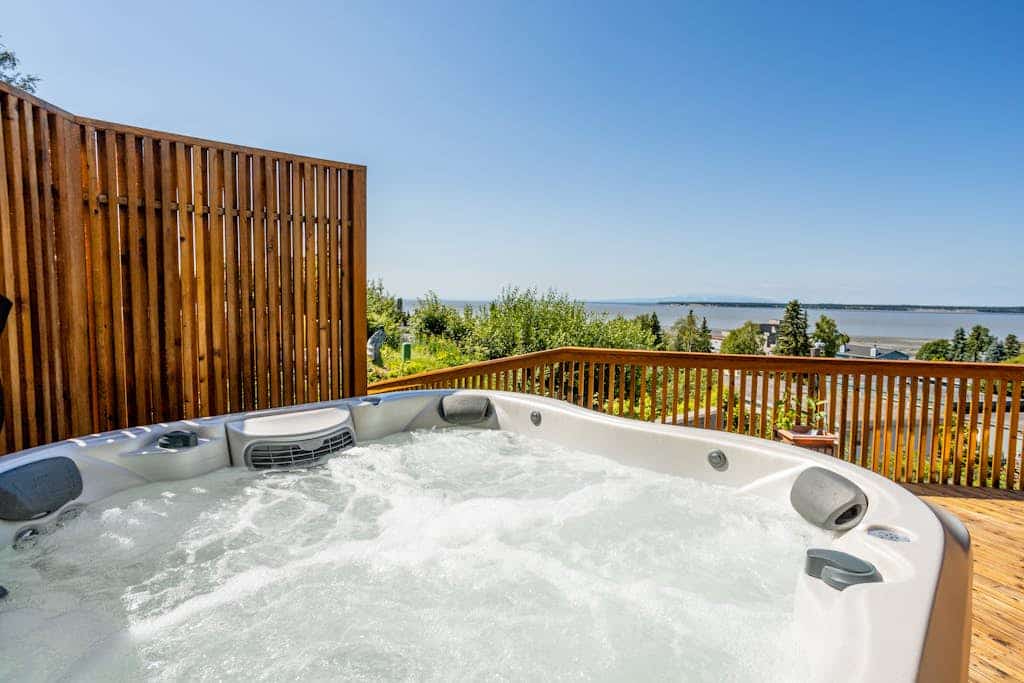 The complete, park-like M Street estate—combining three independent, high-end mid-century modern vacation rentals into a single downtown Anchorage triplex compound. Offering three independent private hot tubs, a lushly landscaped shared garden paradise, pro gas grills, and alfresco dining decks, this property is an unmatched asset built specifically for weddings, corporate retreats, reunions, and large-scale group getaways. The expansive Cook Inlet and mountain views continue inside, where the top-floor primary residence features an award-winning gourmet kitchen featured in Alaska's Best Kitchens Magazine—packed with a solid redwood island, a Miele cooktop, a steam oven, convection oven, and dual dishwashers. Walking distance to the Coastal Trail, Performing Arts Center, and downtown dining. Standard Specs: Three fully equipped kitchen/kitchenette spaces, grand-prize chef's kitchen, three private hot tubs, shared gardens with gas grills, fireplaces, flat-screen TVs, high-speed WiFi, and keypad entry. Off-street driveway parking for three vehicles. Enforces strict zero-tolerance guest capacity policies. Sleeps 16.