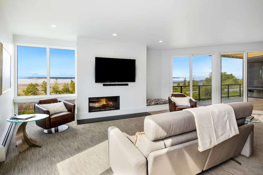 A luxury two-story loft villa in downtown Anchorage built with elegant professional design and high-end finishes engineered for sophisticated comfort. Located in coveted Bootlegger’s Cove, the home captures clean views of Cook Inlet and the Alaska Range from its massive windows, covered balcony, and private rooftop deck. The open floor plan features a built-in wet bar for happy hours, a gourmet kitchen packed with chef-grade appliances, a dual-sided gas fireplace, and a private hot tub standing by on the deck for soothing soaks. Walk to the historic Coastal Trail system or use the provided bicycles to explore 150+ miles of interconnecting trails surrounding the estate. Standard Specs: Chef's kitchen with high-end appliances, private wet bar, rooftop deck, private hot tub, deluxe gas grill, dual-sided fireplace, private bicycles, in-unit laundry, flat-screen Smart TVs, high-speed WiFi, and keypad entry. Parking for two vehicles. Sleeps 10.