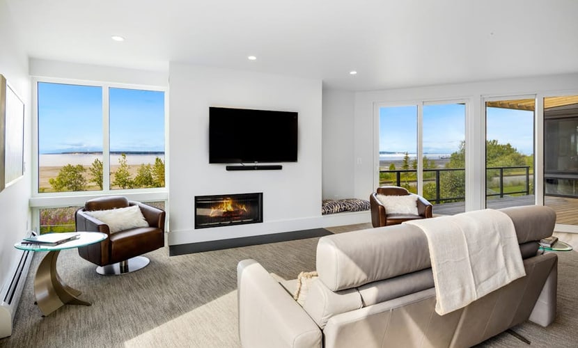 A luxury two-story loft villa in downtown Anchorage built with elegant professional design and high-end finishes engineered for sophisticated comfort. Located in coveted Bootlegger’s Cove, the home captures clean views of Cook Inlet and the Alaska Range from its massive windows, covered balcony, and private rooftop deck. The open floor plan features a built-in wet bar for happy hours, a gourmet kitchen packed with chef-grade appliances, a dual-sided gas fireplace, and a private hot tub standing by on the deck for soothing soaks. Walk to the historic Coastal Trail system or use the provided bicycles to explore 150+ miles of interconnecting trails surrounding the estate. Standard Specs: Chef's kitchen with high-end appliances, private wet bar, rooftop deck, private hot tub, deluxe gas grill, dual-sided fireplace, private bicycles, in-unit laundry, flat-screen Smart TVs, high-speed WiFi, and keypad entry. Parking for two vehicles. Sleeps 10.