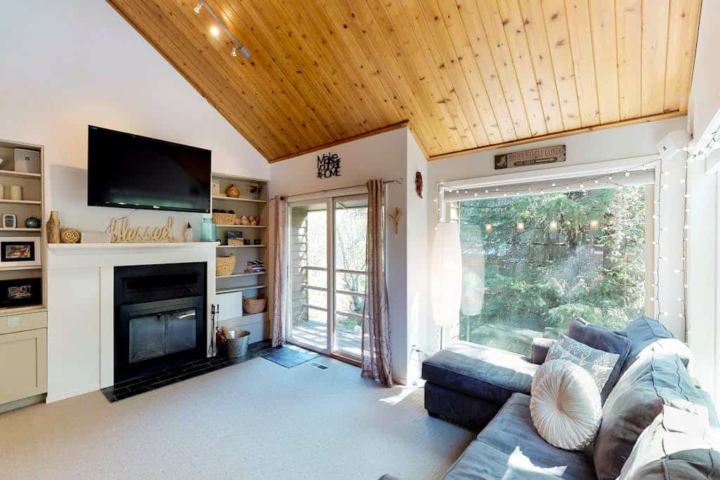 Girdwood lives at a slower rhythm, and this remodeled, split-level condo fits right into it. Tucked into a quiet stand of forest in central Girdwood, the home features clean views out every single window and the kind of quiet that makes you forget how close you are to the village core. The two-story layout easily handles a full crew without feeling crowded, offering a bright living zone centered around a stone gas fireplace, an updated kitchen, and a master bathroom with a deep jetted soaking tub to revive trail-weary legs. Walk out your door to find the local bike path, The Bake Shop, and the local mercantile just minutes away. Standard Specs: Full kitchen with dishwasher, private full-size washer/dryer, flat-screen cable TV, high-speed WiFi, and keypad entry. Dedicated parking for two vehicles. Sleeps 7.