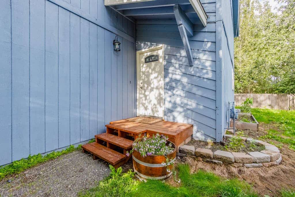 The kind of Anchorage neighborhood home that instantly feels like staying with close friends. Tucked into a quiet residential street with a scenic community walking trail right at the end of the block, the Carriage House boasts quality furnishings, a massive formal dining table, and a completely fenced side yard built for family cookouts on the gas grill. The clean interior features a fully stocked kitchen with real culinary tools, large reclining living room spaces for winding down together, and bedrooms outfitted with premium comfort in mind. A short drive connects you to downtown Anchorage, Kincaid Park, and the Coastal Trail. Dogs are completely welcome to join the team. Standard Specs: Fully equipped kitchen, private fenced yard, gas grill, private washer/dryer, flat-screen TV, high-speed WiFi, and keypad entry. Driveway parking for one vehicle. Fireplace non-operational. Dog-friendly. Sleeps 6.