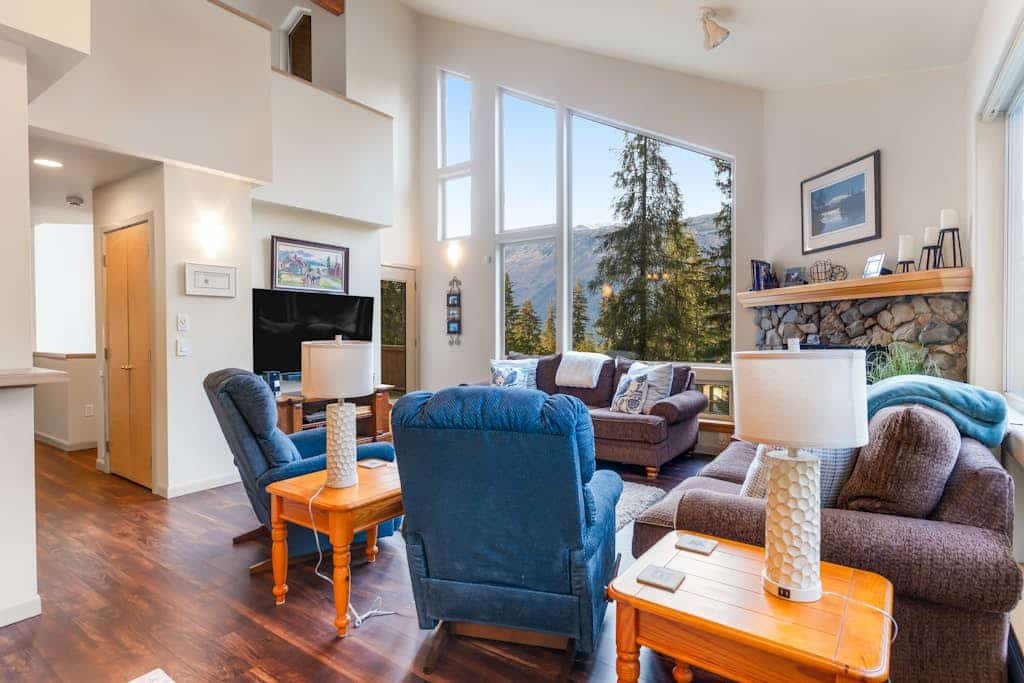 Penguin Ridge sits directly across the valley—and from the private deck of this peaceful family cabin, it completely owns the view. Enclosed by mature spruce and hemlock, this property feels completely isolated from the rest of the world while sitting less than a mile from the Alyeska Resort Day Lodge and Girdwood’s village center. The cabin architecture features high windows that flood the rustic interior with natural light, a ceramic log fireplace that anchors the open family living room, and a massive upstairs sleeping loft that easily handles extra guests and kids. Spend your days exploring the Chugach wilderness, and your nights soaking in the private hot tub under the trees. Standard Specs: Fully equipped kitchen, private outdoor hot tub, ceramic log fireplace, sleeping loft, private washer/dryer, flat-screen TV, high-speed WiFi, and hospitality check-in instructions. Driveway parking for up to four vehicles. Strict quiet hour compliance (10 PM–8 AM). Non-smoking. Sleeps 10.