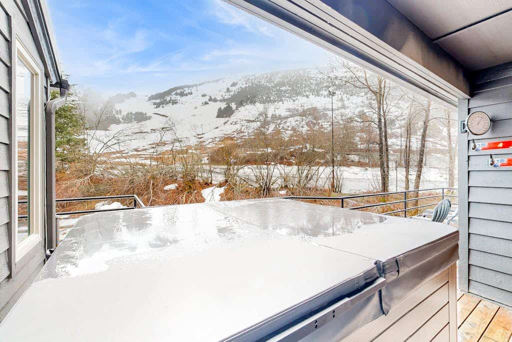 The private outdoor hot tub is brand-new and ultra-luxury—but the real asset is the dramatic, completely unobstructed view of Mount Alyeska it points at. This sun-filled, three-story slopeside townhome sits directly at the base of the lifts, within easy walking distance of the chairlifts and local village restaurants. The ground floor features a high-utility entryway and an oversized mudroom designed specifically for heavy ski or biking gear. The second floor opens into an expansive living, kitchen, and dining area perfect for seamless group hosting, leading directly out to a gas BBQ deck. Includes Apple TV equipped with complimentary Hulu and Netflix accounts. Standard Specs: Fully equipped kitchen, brand-new ultra-luxury outdoor hot tub, gas BBQ deck, mudroom gear staging area, Apple TV (with complimentary corporate Netflix/Hulu), flat-screen TV, high-speed WiFi, and keypad entry. Dedicated parking for three vehicles. Three-story layout. Sleeps 8.