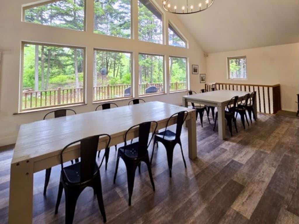 The premium upper-level residence of the Monarch Mine estate—a newly remodeled six-bedroom plus loft duplex layout that comfortably accommodates up to fifteen guests with exceptional space, high vaulted ceilings, and modern structural finishes. Large windows flood the interior with natural light and frame crisp views of the surrounding peaks, while a massive, fully equipped kitchen handles large-scale group meals effortlessly. Step out onto the expansive private deck that runs the length of the home for morning coffee, or drop directly onto the Bird-to-Gird biking path right outside your door. Less than a 12-minute walk to coffee, pizza, and fuel at Girdwood Station. Standard Specs: Large fully equipped kitchen, expansive private deck, flat-screen TVs with streaming access, high-speed WiFi, premium bedding, and keypad entry. Upper duplex layout. Driveway parking for up to six vehicles. 5-minute walk to Girdwood Train Depot. Sleeps 15.