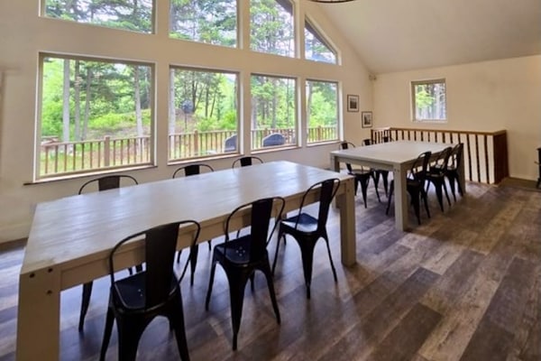 The premium upper-level residence of the Monarch Mine estate—a newly remodeled six-bedroom plus loft duplex layout that comfortably accommodates up to fifteen guests with exceptional space, high vaulted ceilings, and modern structural finishes. Large windows flood the interior with natural light and frame crisp views of the surrounding peaks, while a massive, fully equipped kitchen handles large-scale group meals effortlessly. Step out onto the expansive private deck that runs the length of the home for morning coffee, or drop directly onto the Bird-to-Gird biking path right outside your door. Less than a 12-minute walk to coffee, pizza, and fuel at Girdwood Station. Standard Specs: Large fully equipped kitchen, expansive private deck, flat-screen TVs with streaming access, high-speed WiFi, premium bedding, and keypad entry. Upper duplex layout. Driveway parking for up to six vehicles. 5-minute walk to Girdwood Train Depot. Sleeps 15.
