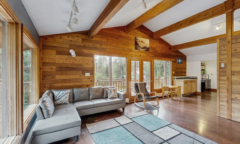 The kind of Girdwood home that completely earns the word welcoming—offering a warm, timber-accented open layout, comfortable bedrooms, and a fully equipped kitchen built for hosting dinners with friends at the end of a long trail day. Step out onto the private forested deck to unwind under the stars in your luxury outdoor hot tub, or stoke the fireplace inside. Positioned just a few minutes from the chairlifts at Alyeska Resort, the home sits within easy walking distance of the Alyeska Nordic Spa, the Double Musky Inn, and Girdwood Brewing Company. Dogs are welcome to join. Standard Specs: Fully equipped kitchen, private outdoor hot tub, fireplace, flat-screen TV, high-speed WiFi, and keypad entry. Driveway parking for two vehicles. Dog-friendly. Sleeps 7.