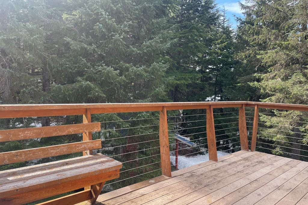 The exact kind of bright, open-concept one-bedroom home you would actually choose to live in full-time. Large upper-level architectural windows pull the mountain and valley views right into the main living room, while a private balcony pushes you straight out into the fresh Girdwood air. The intelligent multi-level layout features a full eat-in dining bar, an updated kitchen, and a lower-level master bedroom with an oversized walk-in closet and private laundry. A dedicated downstairs bonus room cleanly handles yoga practice, remote work, or quiet gear storage. Located a brief drive to Alyeska Resort and steps from local trail loops and breweries. Standard Specs: Full kitchen with dishwasher, private balcony, walk-in closet, full-size utility washer/dryer, dedicated yoga/storage room, board games, flat-screen TV with Netflix streaming, high-speed WiFi, and keypad entry. Driveway parking for two vehicles. Sleeps 5.