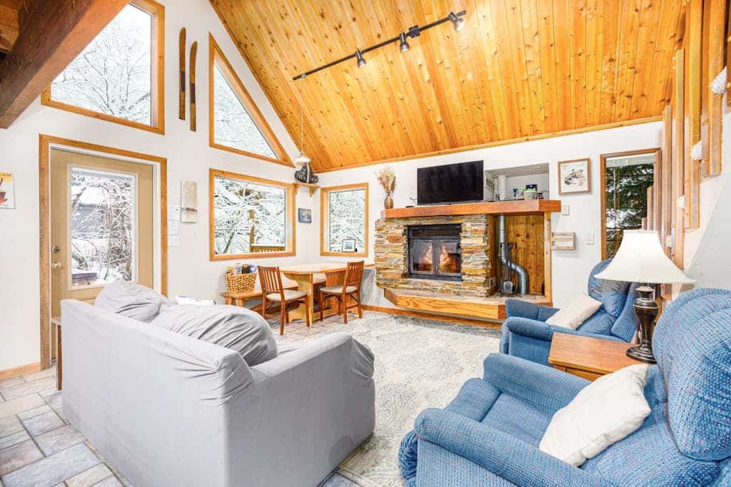 A classic mountain chalet that delivers authentic cabin warmth, positioned just an easy walk from the main chairlifts at Alyeska Resort. Built with large architectural windows that draw the Chugach peaks inside, this multi-level layout is the perfect staging ground for deep-powder winters or summer trail campaigns up Crow Pass and Winner Creek. The interior centers around a traditional wood-burning fireplace, a fully equipped kitchen built for hosting hearty post-trail meals, and a flexible loft space that cleanly handles extra guests. Dogs are welcome to join the adventure, and the private balcony offers a quiet place for morning coffee in the forest. *Please note: The footpath to the entrance involves authentic wooden walkways and uneven stairs.* Standard Specs: Fully equipped kitchen, wood-burning fireplace, smart streaming TV, high-speed WiFi, and keypad entry. Dedicated parking for two vehicles. No A/C. Dog-friendly. Sleeps 6.