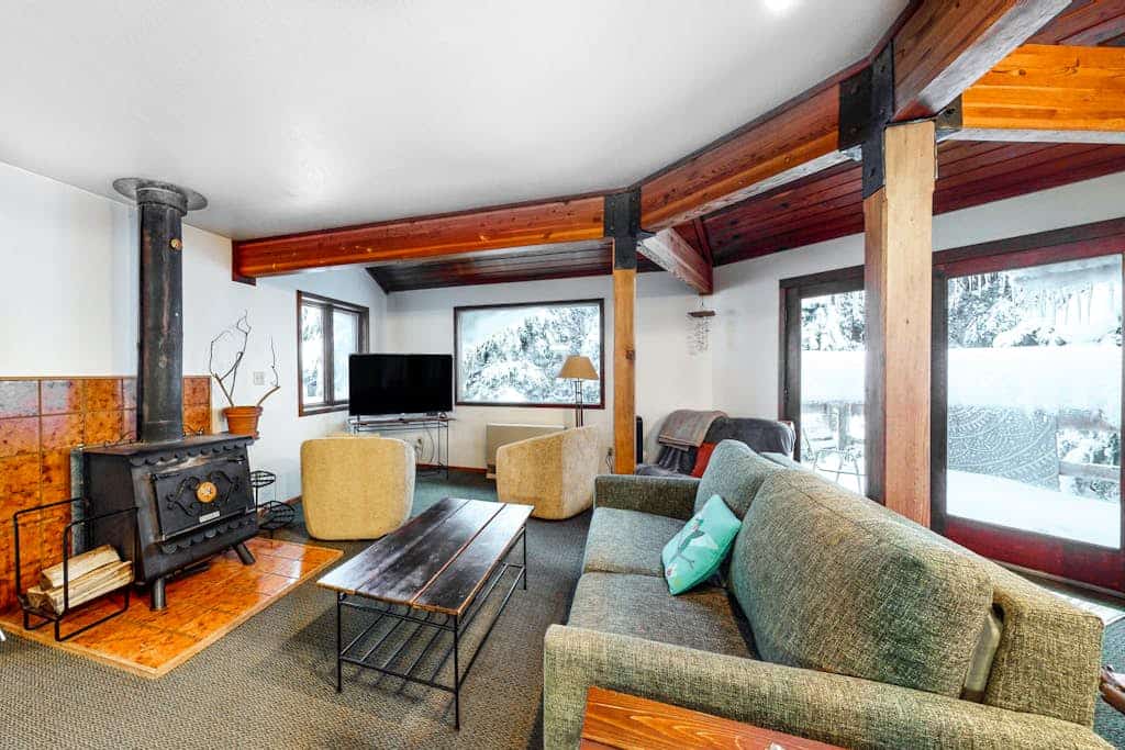 A dense spruce forest closes in on three sides of this striking open-beam chalet, delivering deep serenity just a short drive from Alyeska Resort and minutes from Girdwood’s local trailheads and breweries. The architecture features soaring big-beam construction and massive windows that bring the old-growth canopy right into your living room. The layout is defined by two standout features: a sun-drenched glass solarium that turns morning coffee into a slow ritual, and a massive private hot tub on the back deck for starlit evening wind-downs. The interior is warm and human, featuring a powerful wood stove, recent premium flooring updates, and a dog-friendly policy. Standard Specs: Fully equipped kitchen, private full-size washer/dryer, wood stove, flat-screen TV, high-speed WiFi, and keypad entry. Driveway parking for up to three vehicles. Dog-friendly. Sleeps 9.