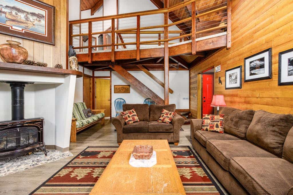 Big timber beams, soaring vaulted ceilings, and a private hot tub waiting under the spruce canopy—Vail Chalet delivers an authentic lodge-style retreat. Located a short walk from Girdwood’s trailheads and a brief drive to Alyeska Resort, the home looks out over the mountain lights in the winter and wild berry patches in the summer. The interior has been completely updated to meet modern standards, featuring a premium kitchen with a new LG refrigerator, fresh furnishings, and a primary bedroom suite with its own private gas fireplace. A second fireplace anchors the main living room, offering a warm sanctuary for groups and their dogs. Standard Specs: Fully equipped kitchen, private outdoor hot tub, two fireplaces, propane grill, private washer/dryer, cable TV/DVD, high-speed WiFi, and keypad entry. Parking for two vehicles. Dog-friendly. Sleeps 8.