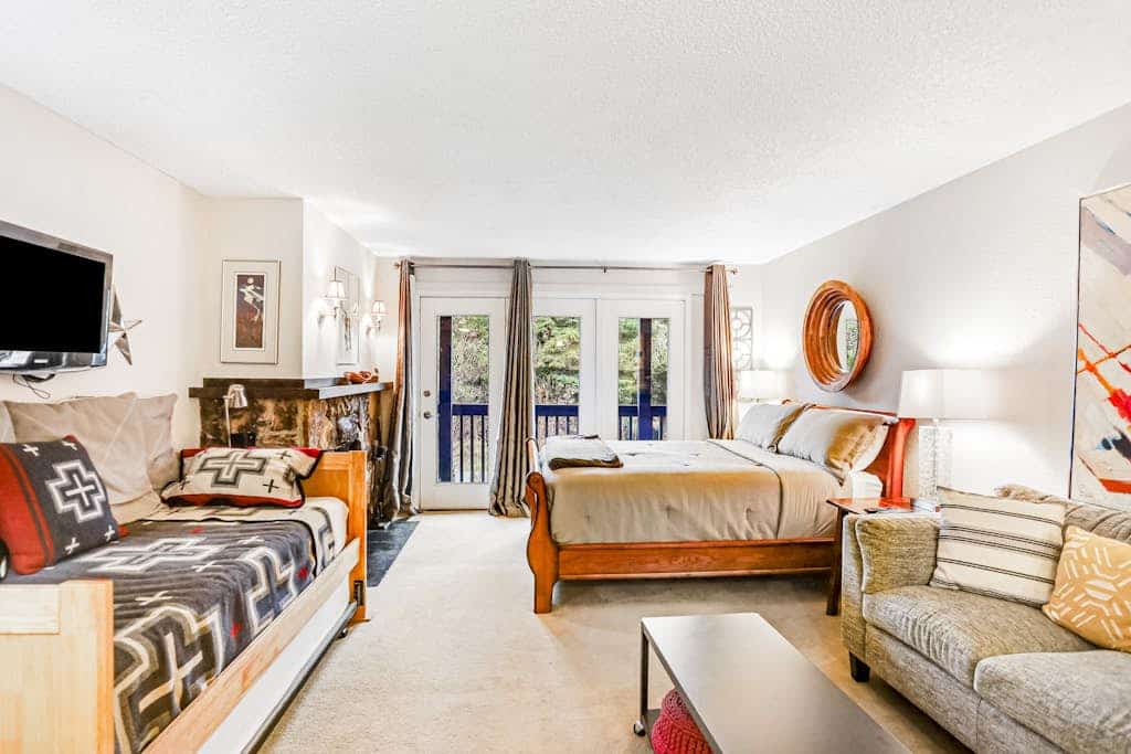 A crisp, practical studio condo positioned a short walk from the Alyeska chairlifts in central Girdwood, making it the ideal basecamp for travelers who would rather spend their time exploring the mountain than sitting inside a room. The floor plan focuses entirely on utility, offering a private balcony for morning mountain views, a well-equipped kitchen with a full dishwasher, and immediate access to the building's deep-heat shared sauna to flush out the miles after a long day on the snow. Walking distance to the village's best restaurants, art galleries, and grocery loops. Standard Specs: Well-equipped kitchen with dishwasher, private balcony, flat-screen cable TV, high-speed WiFi, keypad entry, and shared building sauna. Parking for one vehicle. Fireplace is decorative/non-operational. No A/C. Sleeps 4.