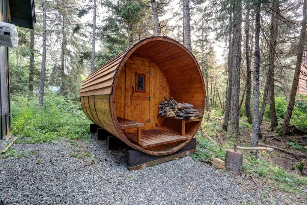 The authentic cedar barrel sauna sitting right outside the front door is wood-fired, completely real, and the undisputed centerpiece of any mountain trip here. Hanging Glacier Chalet is a premium, high-capacity lodge engineered specifically for large groups, outdoor teams, and ski weeks. The structural interior features towering vaulted ceilings that draw in natural light, electric floor heating in the entryway and both bathrooms, and a pro kitchen packed with specialty bakeware. Step out onto the deck to use the private gas grill, or catch the free town shuttle loop located just 2.5 miles from Alyeska Resort. *Utilizes privacy-compliant decibel monitoring sensors.* Standard Specs: Pro-stocked full kitchen with specialized bakeware, private wood-fired outdoor sauna, electric floor heat, private gas grill, large-capacity washer/dryer, high-speed WiFi, and keypad entry. Parking for two vehicles. 4WD required in winter. Sleeps 8.
