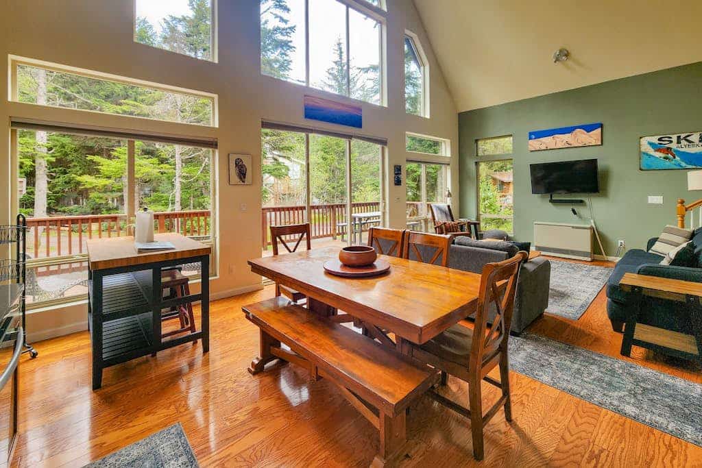 The authentic cedar barrel sauna sitting right outside the front door is wood-fired, completely real, and the undisputed centerpiece of any mountain trip here. Hanging Glacier Chalet is a premium, high-capacity lodge engineered specifically for large groups, outdoor teams, and ski weeks. The structural interior features towering vaulted ceilings that draw in natural light, electric floor heating in the entryway and both bathrooms, and a pro kitchen packed with specialty bakeware. Step out onto the deck to use the private gas grill, or catch the free town shuttle loop located just 2.5 miles from Alyeska Resort. *Utilizes privacy-compliant decibel monitoring sensors.* Standard Specs: Pro-stocked full kitchen with specialized bakeware, private wood-fired outdoor sauna, electric floor heat, private gas grill, large-capacity washer/dryer, high-speed WiFi, and keypad entry. Parking for two vehicles. 4WD required in winter. Sleeps 8.