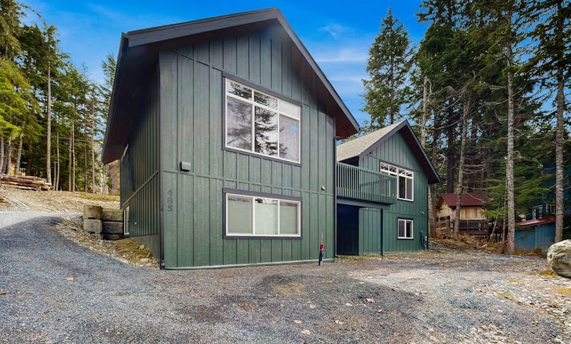 Penguin Ridge sits directly across the valley, the Virgin Creek Trailhead sits within easy walking distance, and the Girdwood breweries and local fishing charters are just a brief drive down the road. Unit A is a cozy, open-concept two-bedroom side of our modern mountainside duplex, engineered to handle a small family with complete comfort. The bright interior layout features a large living room with an oversized sofa, a flat-screen Smart TV, and a fully equipped kitchen with stainless steel appliances and ample prep space. Walk out onto the deck to access the shared grilling space and take in the gorgeous, crisp views of the surrounding Girdwood wilderness. Pairs with Unit B for larger group bookings. Standard Specs: Fully equipped kitchen with stainless steel appliances, shared deck with gas grill, mountain views, private washer/dryer, flat-screen Smart TV, child's toys, Pack-N-Play, high-speed WiFi, and keypad entry. Dedicated parking for one vehicle. No A/C. Sleeps 6.