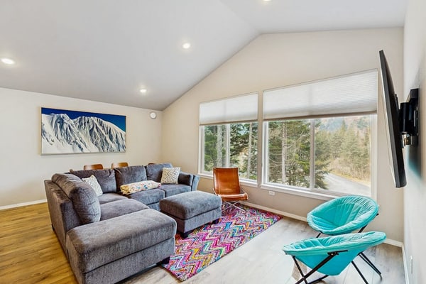 Penguin Ridge sits directly across the valley, the Virgin Creek Trailhead sits within easy walking distance, and the Girdwood breweries and local fishing charters are just a brief drive down the road. Unit A is a cozy, open-concept two-bedroom side of our modern mountainside duplex, engineered to handle a small family with complete comfort. The bright interior layout features a large living room with an oversized sofa, a flat-screen Smart TV, and a fully equipped kitchen with stainless steel appliances and ample prep space. Walk out onto the deck to access the shared grilling space and take in the gorgeous, crisp views of the surrounding Girdwood wilderness. Pairs with Unit B for larger group bookings. Standard Specs: Fully equipped kitchen with stainless steel appliances, shared deck with gas grill, mountain views, private washer/dryer, flat-screen Smart TV, child's toys, Pack-N-Play, high-speed WiFi, and keypad entry. Dedicated parking for one vehicle. No A/C. Sleeps 6.
