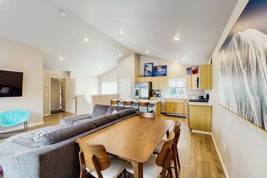 Penguin Ridge sits directly across the valley, the Virgin Creek Trailhead sits within easy walking distance, and the Girdwood breweries and local fishing charters are just a brief drive down the road. Unit A is a cozy, open-concept two-bedroom side of our modern mountainside duplex, engineered to handle a small family with complete comfort. The bright interior layout features a large living room with an oversized sofa, a flat-screen Smart TV, and a fully equipped kitchen with stainless steel appliances and ample prep space. Walk out onto the deck to access the shared grilling space and take in the gorgeous, crisp views of the surrounding Girdwood wilderness. Pairs with Unit B for larger group bookings. Standard Specs: Fully equipped kitchen with stainless steel appliances, shared deck with gas grill, mountain views, private washer/dryer, flat-screen Smart TV, child's toys, Pack-N-Play, high-speed WiFi, and keypad entry. Dedicated parking for one vehicle. No A/C. Sleeps 6.