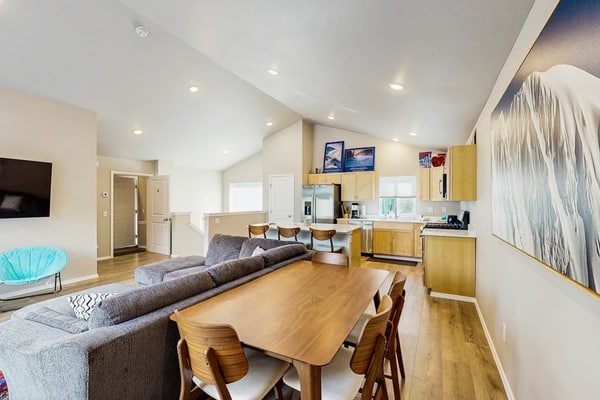 Penguin Ridge sits directly across the valley, the Virgin Creek Trailhead sits within easy walking distance, and the Girdwood breweries and local fishing charters are just a brief drive down the road. Unit A is a cozy, open-concept two-bedroom side of our modern mountainside duplex, engineered to handle a small family with complete comfort. The bright interior layout features a large living room with an oversized sofa, a flat-screen Smart TV, and a fully equipped kitchen with stainless steel appliances and ample prep space. Walk out onto the deck to access the shared grilling space and take in the gorgeous, crisp views of the surrounding Girdwood wilderness. Pairs with Unit B for larger group bookings. Standard Specs: Fully equipped kitchen with stainless steel appliances, shared deck with gas grill, mountain views, private washer/dryer, flat-screen Smart TV, child's toys, Pack-N-Play, high-speed WiFi, and keypad entry. Dedicated parking for one vehicle. No A/C. Sleeps 6.