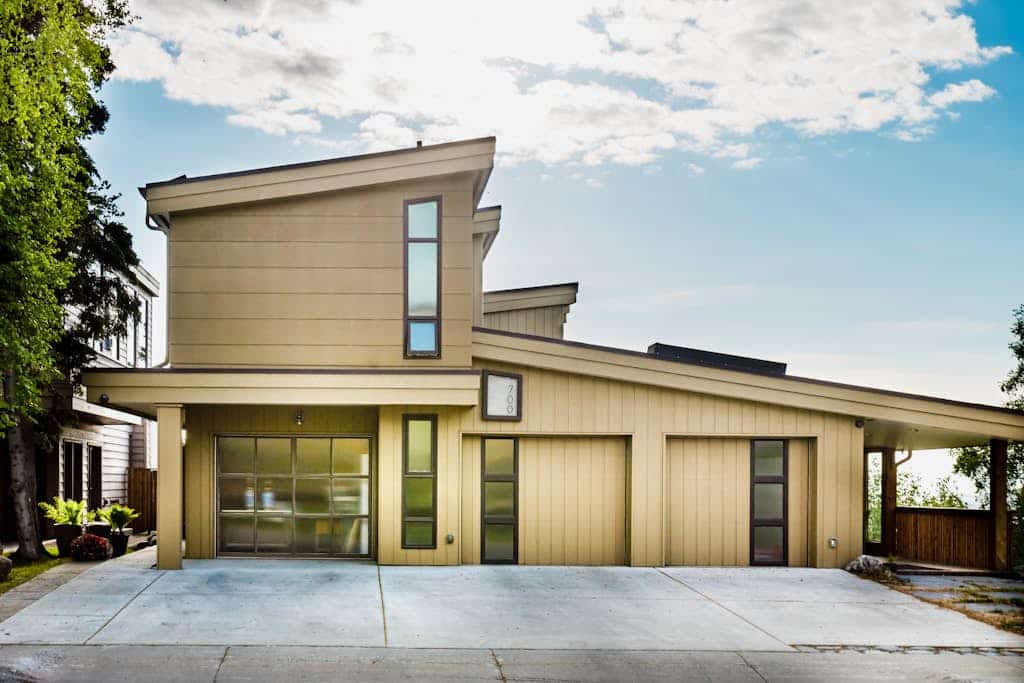 This high-utility group rental combines two independent, private-entry condos within the luxury M Street downtown Anchorage triplex into a single, connected three-bedroom configuration via a shared outdoor alcove patio. It is the perfect operational call when you need more scale than a single unit but don't require the full property compound. The interior showcases sleek industrial finishes, a built-in gas fireplace, a full kitchen plus an independent second kitchenette, and a master suite with walk-out access to the large garden patio. Outside, the grounds offer two completely private hot tubs and a shared landscaped garden looking out over Cook Inlet and Mt. Denali on clear days. Walk to the Coastal Trail and downtown eateries. Standard Specs: Full kitchen plus independent kitchenette, built-in gas fireplace, two private outdoor hot tubs, shared garden patio with gas grill, flat-screen TVs, high-speed WiFi, and keypad entry. Off-street parking for two vehicles. Involves a long entryway stairwell. Sleeps 9.
