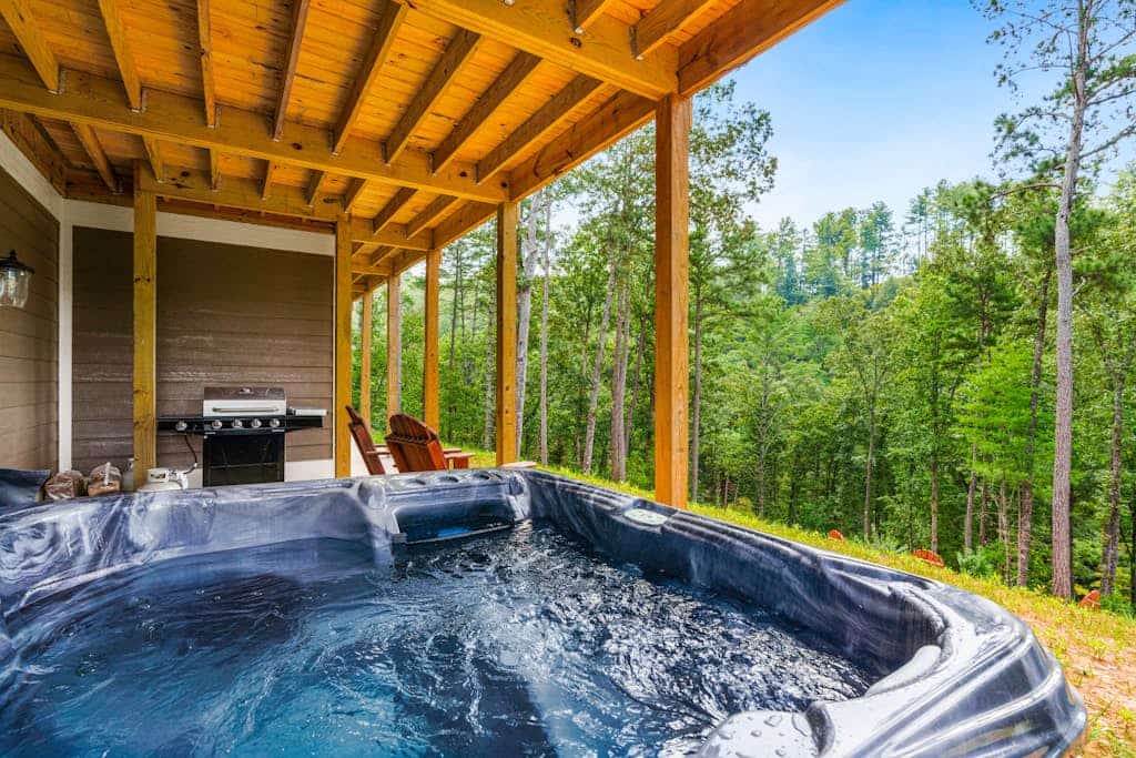 Calming river view Georgia home with fireplace, firepit, balcony, & hot tub