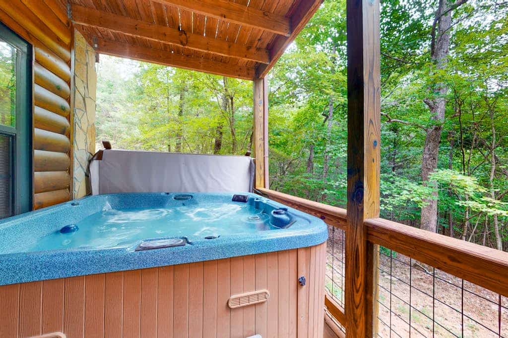 Wooded dog-friendly cabin with games, firepit, screened porch, & private hot tub