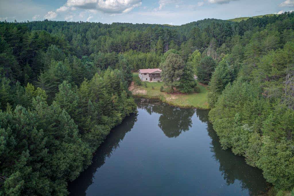 Pond-front cabin with private hot tub, fireplaces, furnished deck, & game room