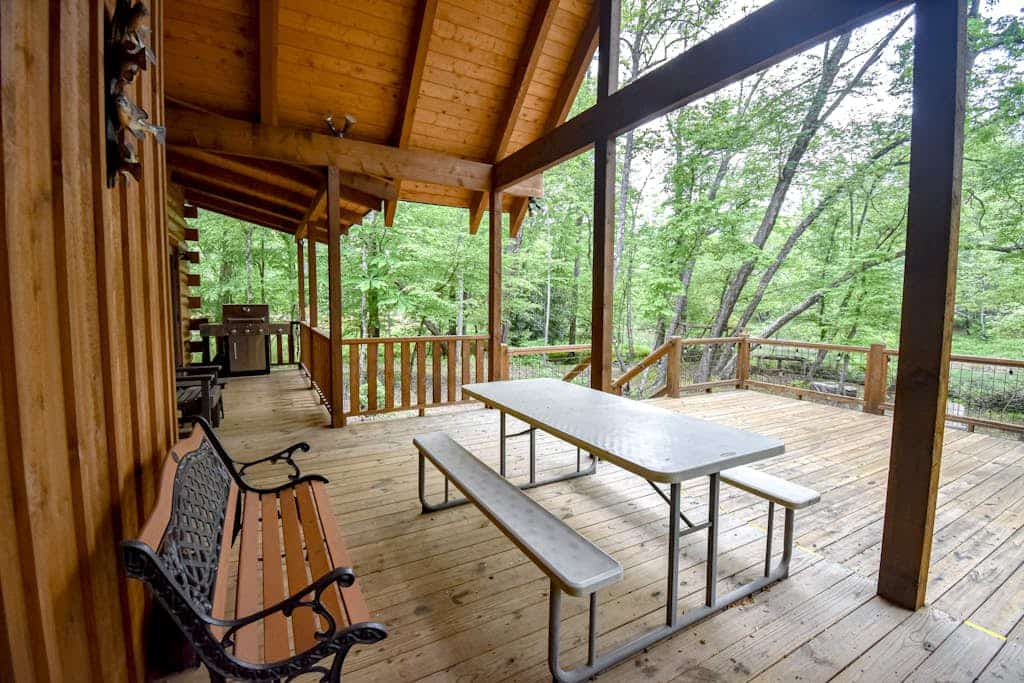 Riverfront cabin with private dock, firepit, wraparound porch & fireplace