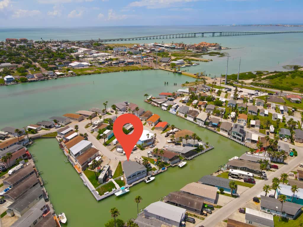 Welcome to Waterfront Oasis, a bright single-level cottage on a quiet canal in the gated Long Island Village resort. Sip coffee on the covered patio while the water glistens just beyond the rail, cast a line from the dock, then settle into one of two restful queen bedrooms. Step out to community pools, an indoor hot tub, par-3 golf, tennis, and pickleball, with South Padre Island beaches a short drive over the causeway. Your Texas Gulf Coast escape starts here.