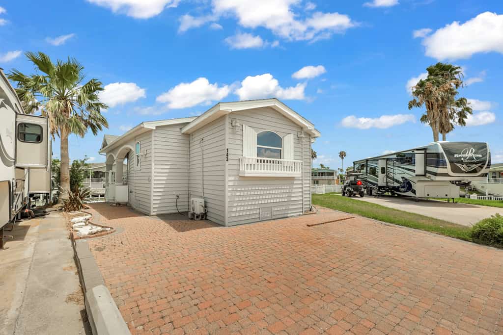 Welcome to Waterfront Oasis, a bright single-level cottage on a quiet canal in the gated Long Island Village resort. Sip coffee on the covered patio while the water glistens just beyond the rail, cast a line from the dock, then settle into one of two restful queen bedrooms. Step out to community pools, an indoor hot tub, par-3 golf, tennis, and pickleball, with South Padre Island beaches a short drive over the causeway. Your Texas Gulf Coast escape starts here.