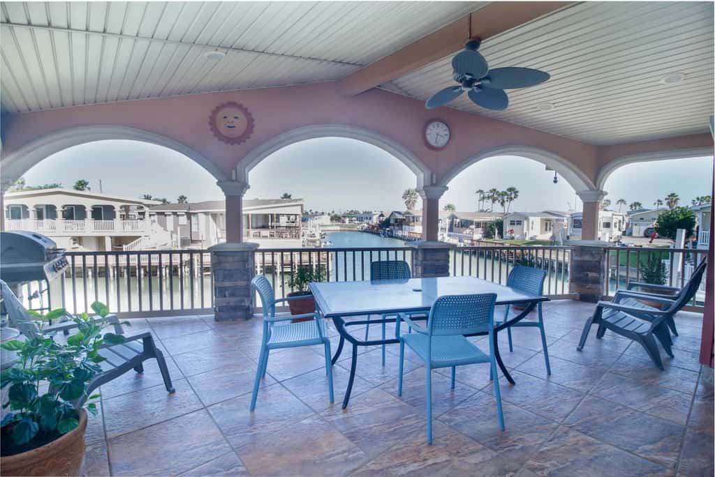 Welcome to Copper Bottom Cottage, a four-bedroom waterfront retreat in the channels of gated Long Island Village. Gather on the spacious covered deck above the canal, fish from the water's edge, and spread out across two levels with room for eight. The lower unit has its own entrance, and every bedroom has a streaming TV. Your stay includes the community's indoor and outdoor pools, hot tubs, par-3 golf, tennis, and marina, with South Padre Island beaches about ten minutes over the causeway.