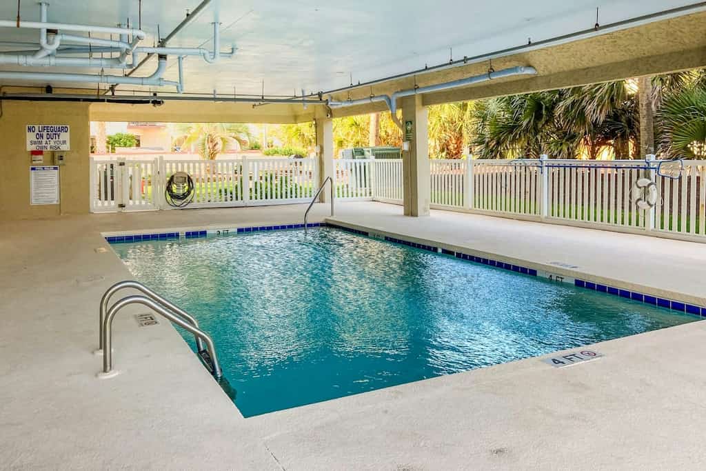 Oceanfront retreat with pool, grill, beach access, streaming, balcony, AC, & W/D