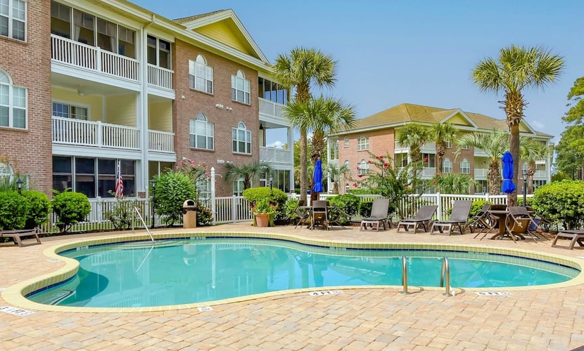Sunny condo with pool access, coastal theme, balcony, W/D, and central AC