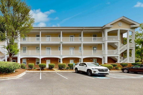 Sunny condo with pool access, coastal theme, balcony, W/D, and central AC