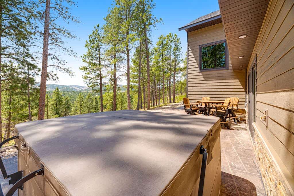 Escape to Whiskey Ridge Lodge, a stunning 5,000 square foot retreat near Deadwood. This 5-bedroom home offers the perfect blend of luxury and comfort, featuring a private hot tub, a spacious rec room with a pool table, and a grand great room with floor to ceiling windows. Ideally located for exploring Mount Rushmore and Deadwood, our lodge provides a premium basecamp for large groups with gourmet kitchens and expansive outdoor dining areas perfect for enjoying the beautiful woodland surroundings.