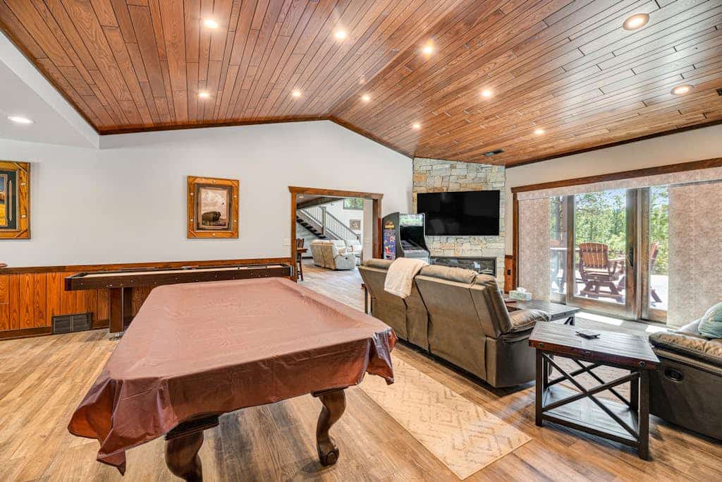 Escape to Whiskey Ridge Lodge, a stunning 5,000 square foot retreat near Deadwood. This 5-bedroom home offers the perfect blend of luxury and comfort, featuring a private hot tub, a spacious rec room with a pool table, and a grand great room with floor to ceiling windows. Ideally located for exploring Mount Rushmore and Deadwood, our lodge provides a premium basecamp for large groups with gourmet kitchens and expansive outdoor dining areas perfect for enjoying the beautiful woodland surroundings.