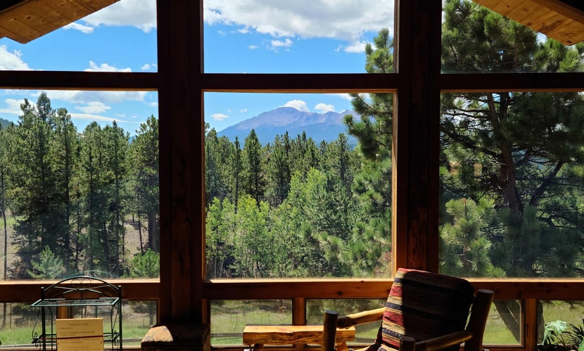 Escape to Mills Ranch, a breathtaking log cabin set on 10 private acres in Woodland Park. Enjoy spectacular views of Pikes Peak from your private hot tub or gather by the cozy wood burning fireplace. This spacious retreat features three bedrooms, a game room with a pool table, and a chef kitchen. Perfectly situated for outdoor adventures, this mountain getaway offers the ultimate Colorado experience for families and groups seeking comfort, privacy, and proximity to scenic hiking and regional attractions.