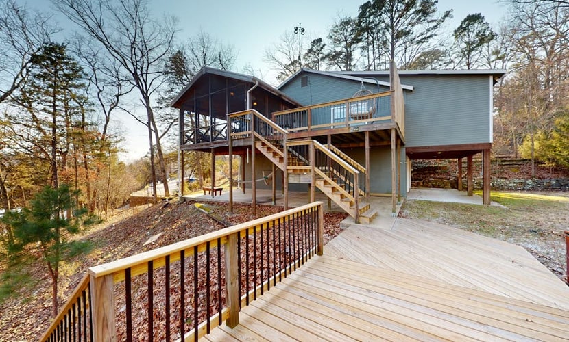 Lakefront retreat with screened sunroom, wood stove, multiple decks, & AC
