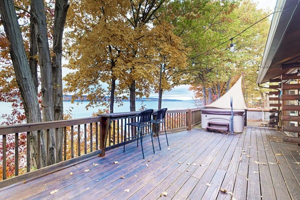 1-acre lakefront log cabin with dock, 50 ft water frontage, hot tub, & deck