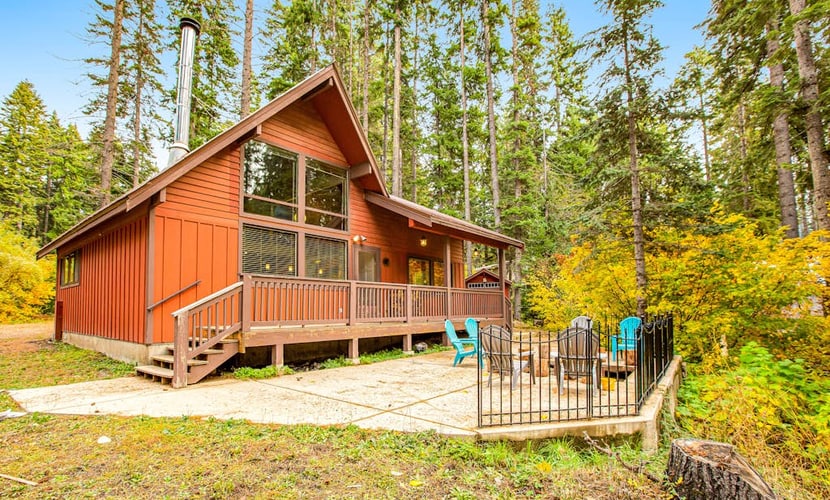 Dog-friendly lakefront home surrounded by trees with wood stove, deck & firepit