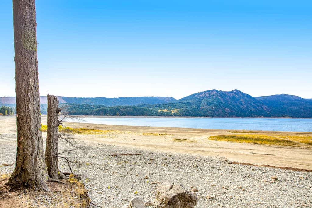 Dog-friendly lakefront home surrounded by trees with wood stove, deck & firepit