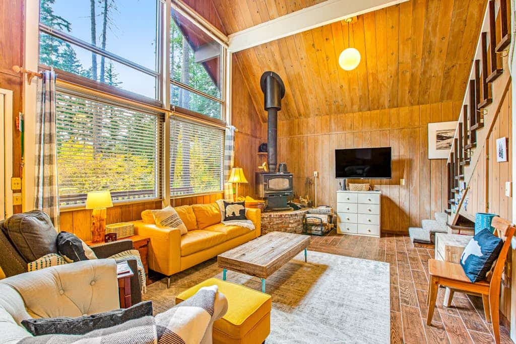 Dog-friendly lakefront home surrounded by trees with wood stove, deck & firepit