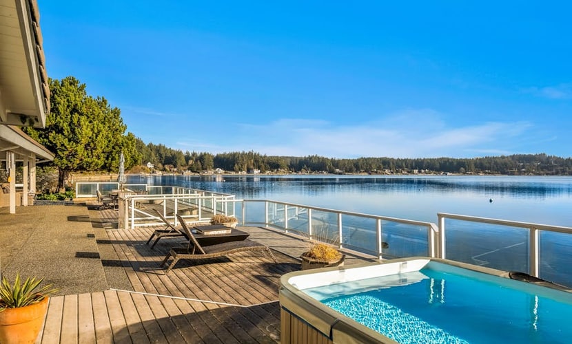 Waterfront home with private hot tub, game room with game tables, and water toys