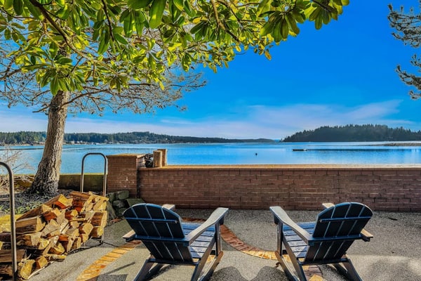 Waterfront home with private hot tub, game room with game tables, and water toys