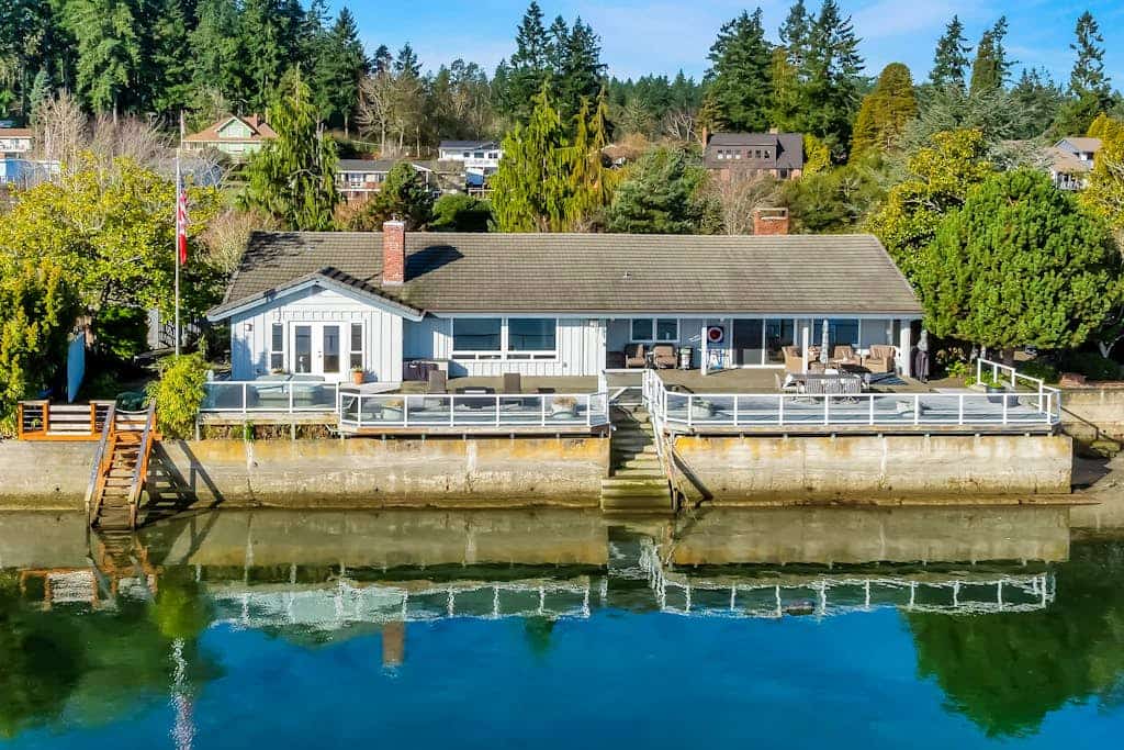Waterfront home with private hot tub, game room with game tables, and water toys