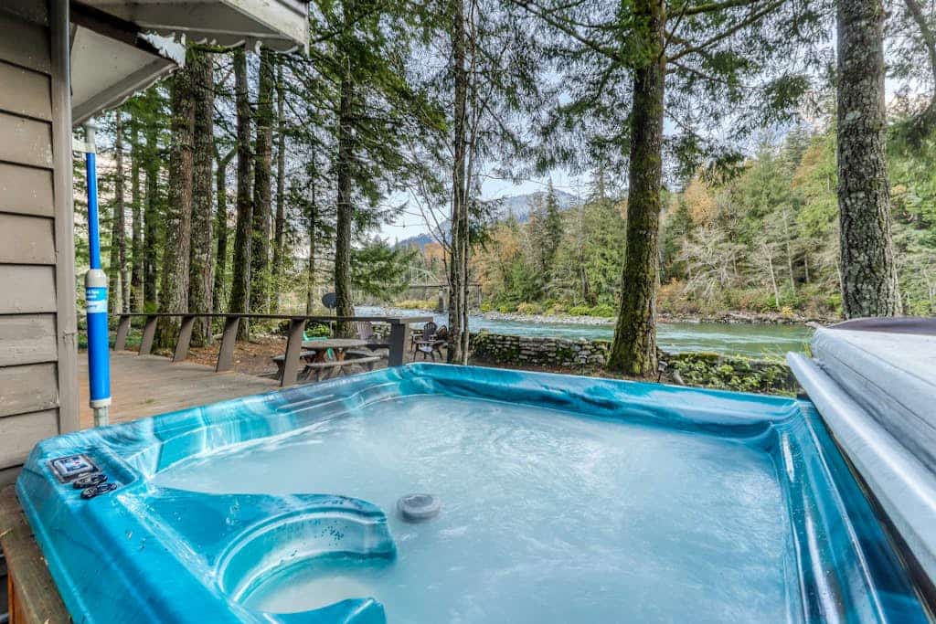Dog-friendly cottage on the river with private hot tub, mountain views & firepit