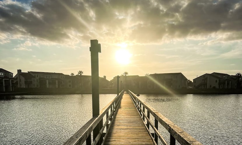 Waterfront condo with bay view, outdoor pool, tennis, dock, balcony, W/D, & AC