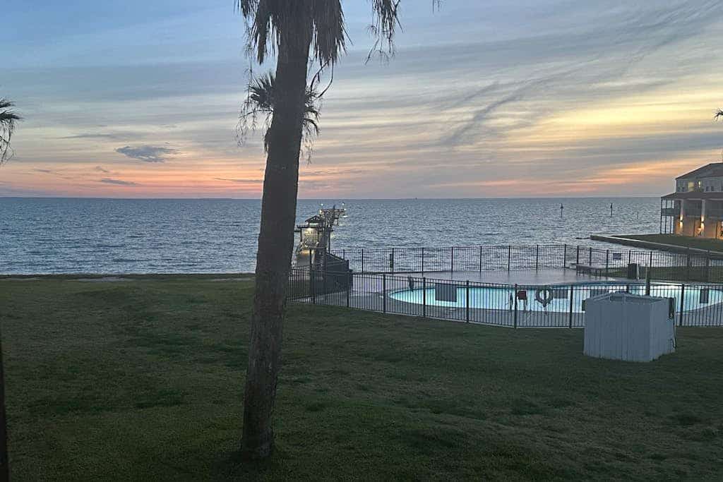 Waterfront condo with bay view, outdoor pool, tennis, dock, balcony, W/D, & AC