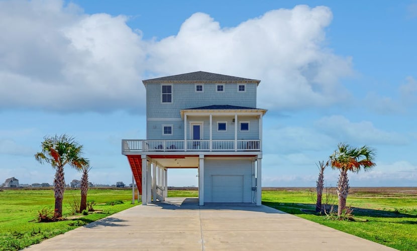 Brand new coastal gem with bay/wetland views, two balconies, & outdoor shower